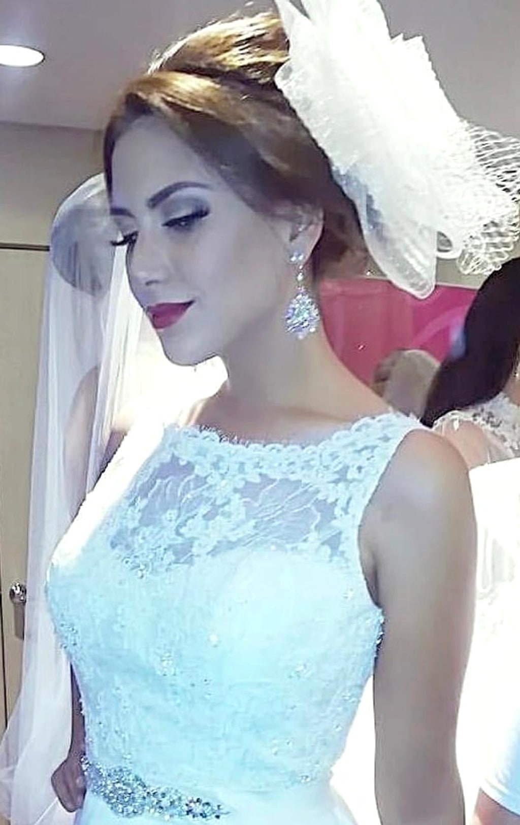 Novia con tocado blanco y maquillaje elegante